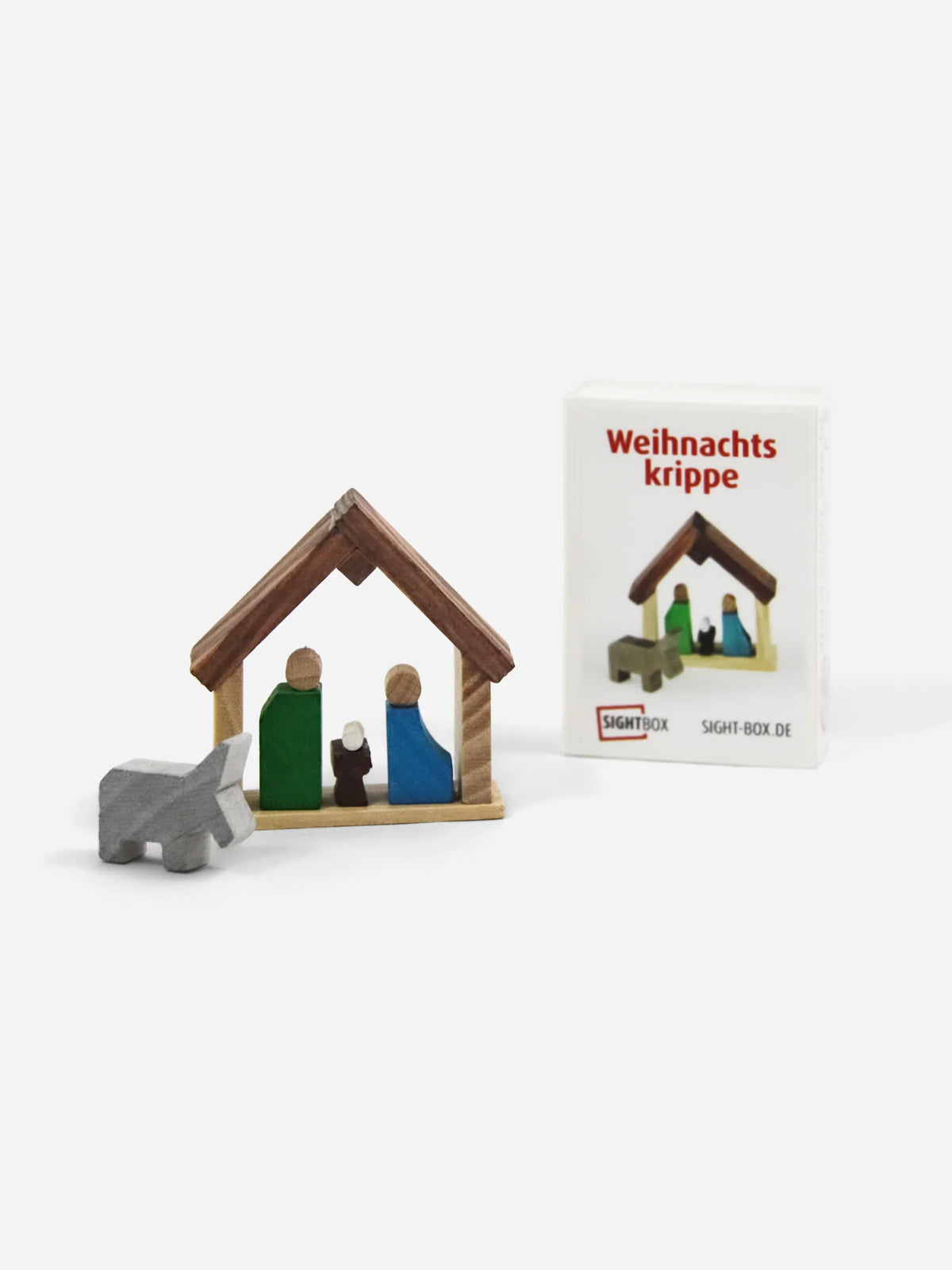 Holzbausatz Weihnachtskrippe mit Maria, Josef, Jesuskind und Esel neben der Sightbox-Schachtel