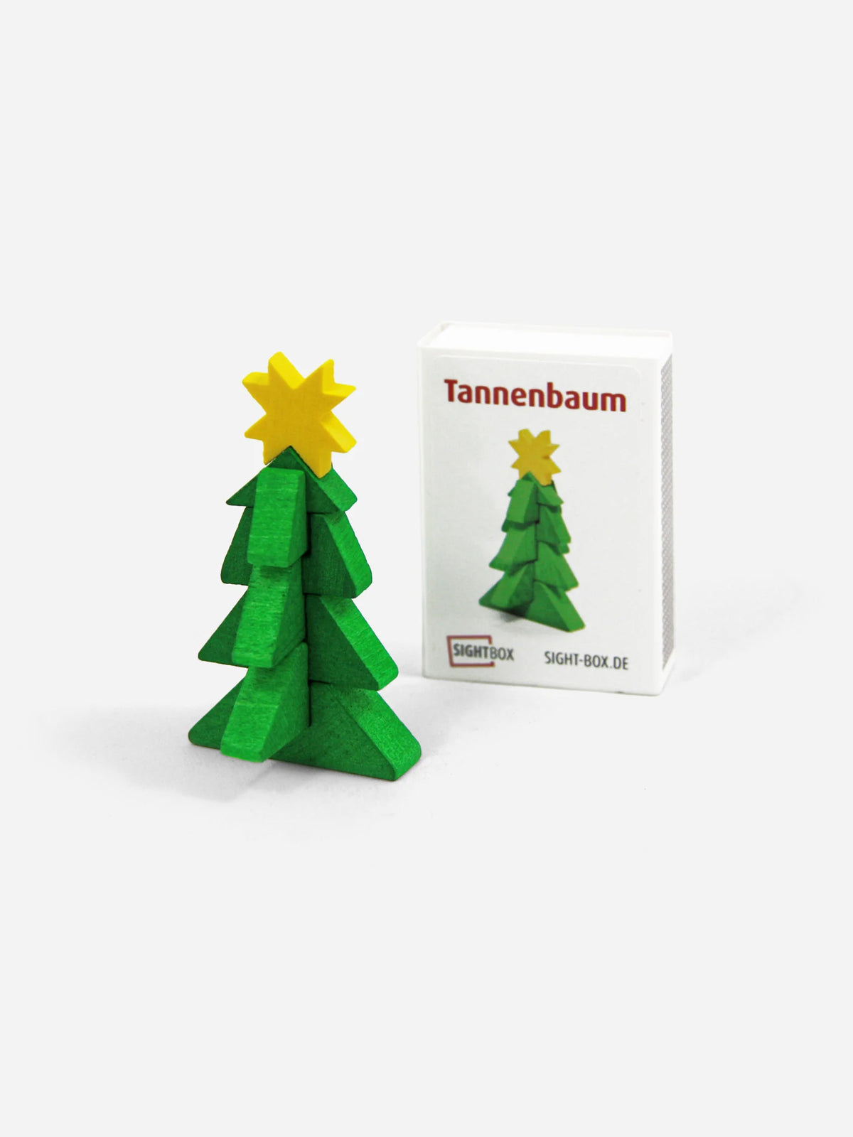 Holzbausatz Tannenbaum: grüner Weihnachtsbaum mit gelbem Stern neben der Sightbox-Schachtel