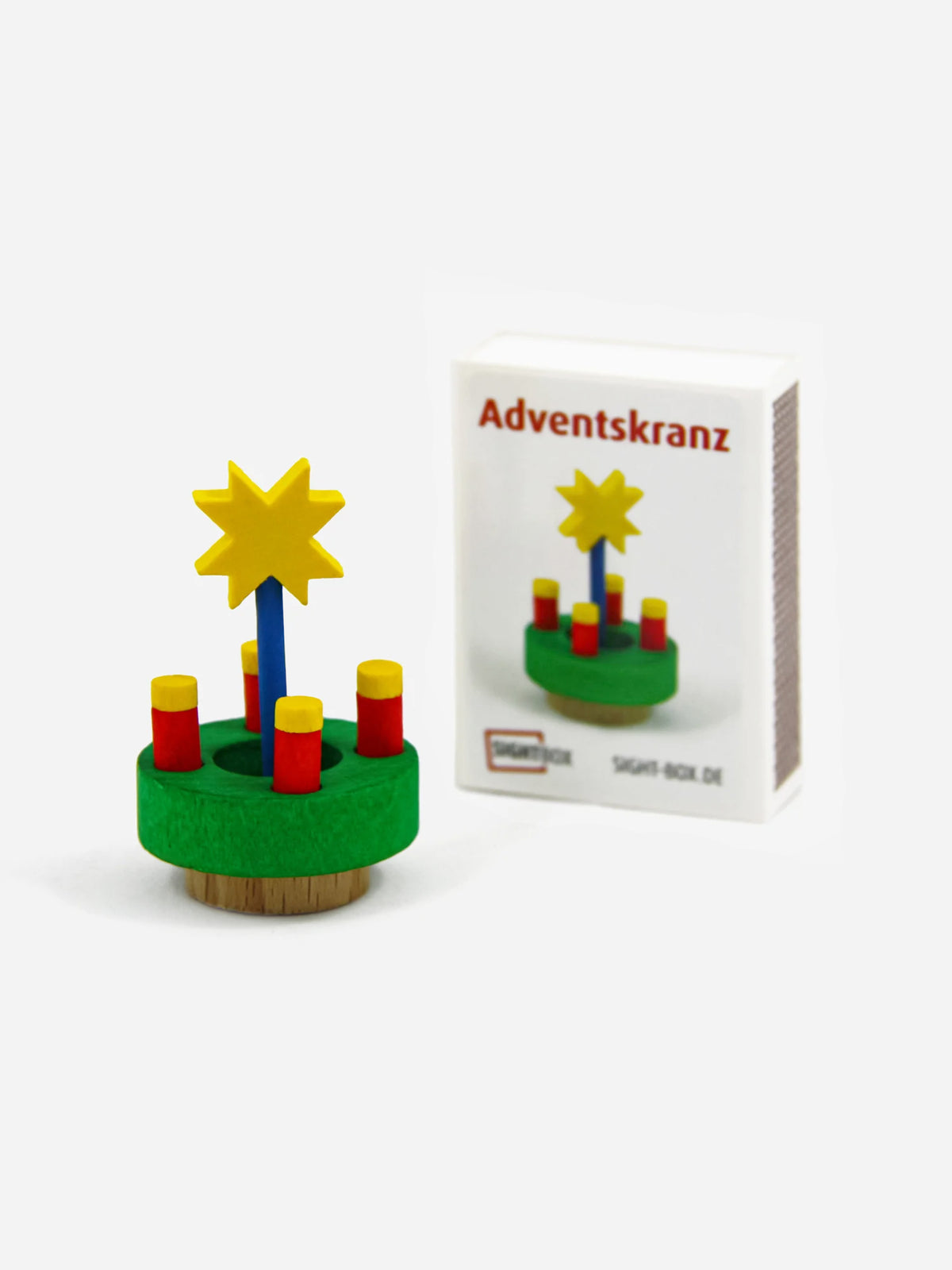 Holzbausatz Adventskranz mit vier rot-gelben Kerzen und gelbem Stern neben der Sightbox-Schachtel