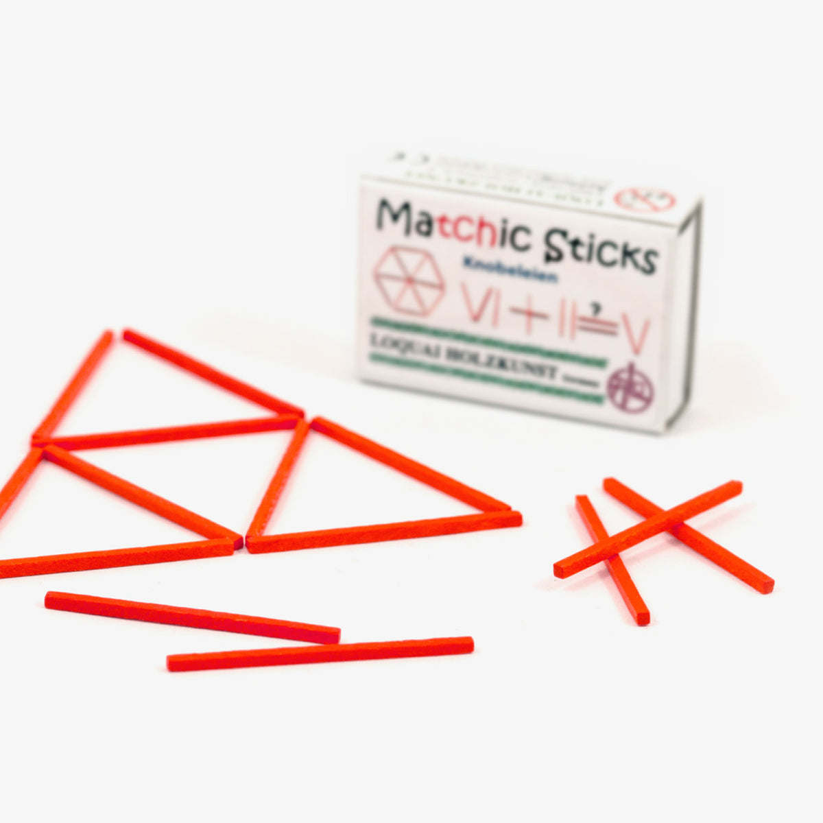 Holzspiel Matchic Sticks: rote Holzstäbchen zu Dreiecken gelegt, dahinter die Streichholzschachtel